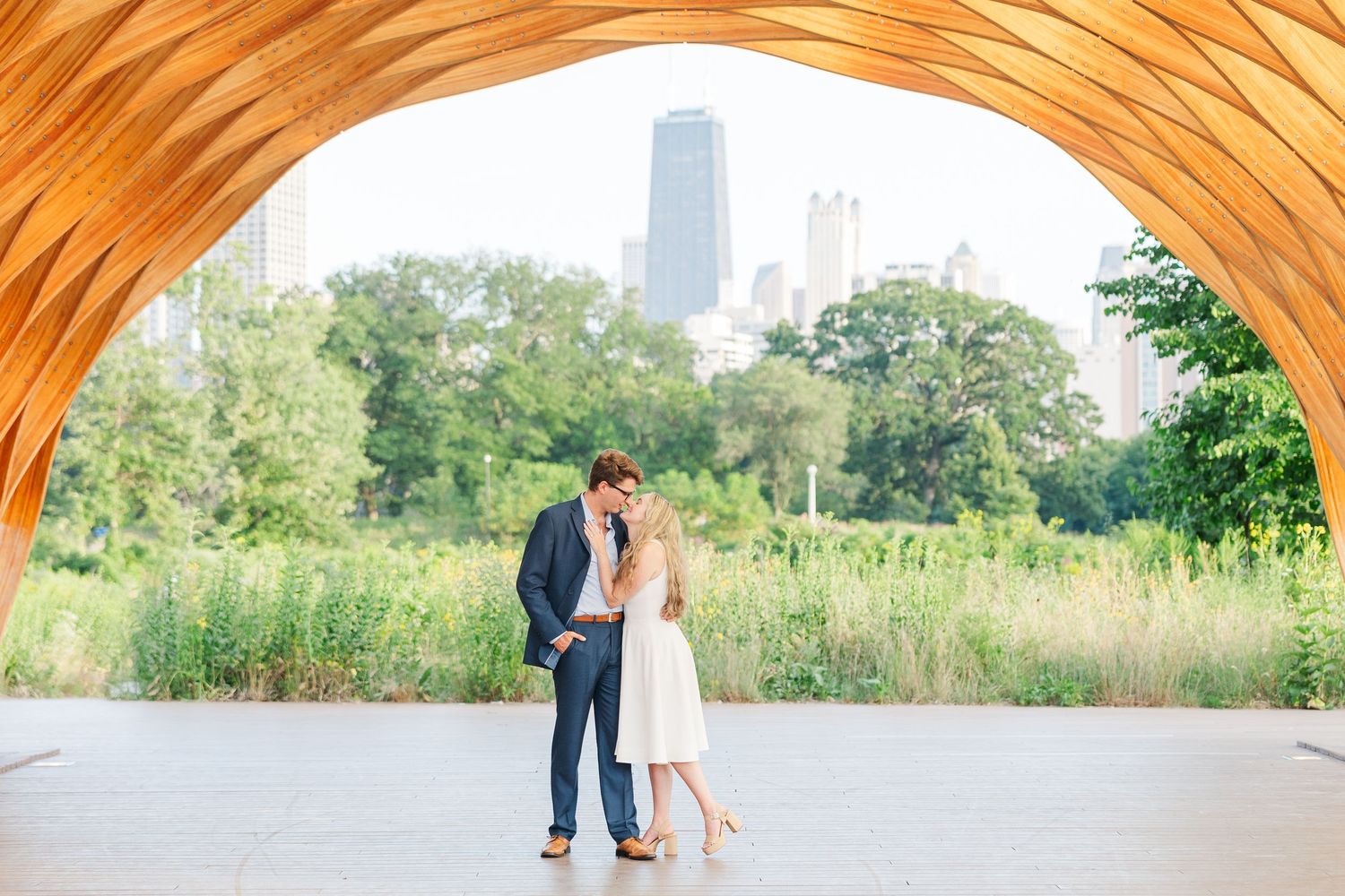 Elizabeth and Joe standing under the Honeycomb Pavilion in Lincoln Park, Chicago, smiling at each other