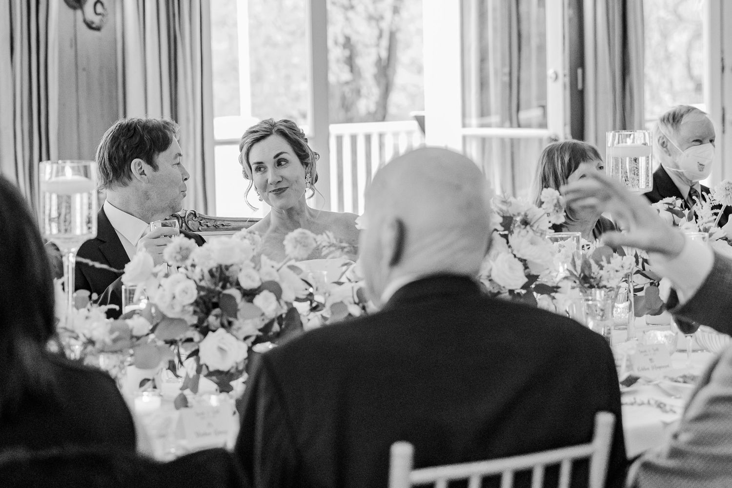 Black and white photo of guests dining at an elegant wedding reception.