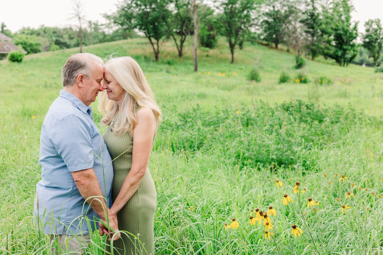 A romantic couple sharing an intimate moment in a meadow with wildflowers.
