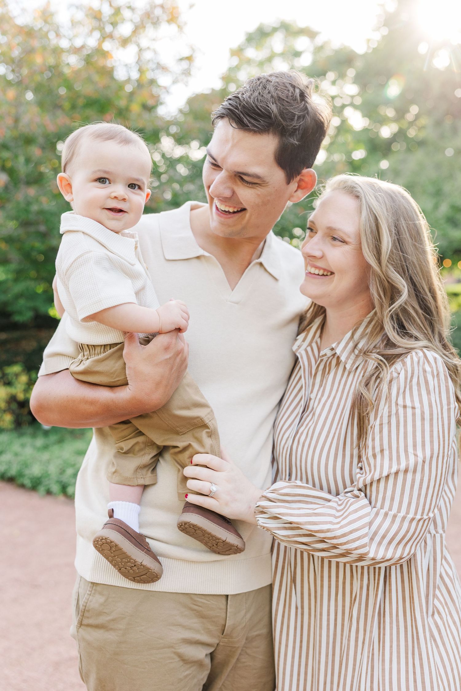 Cantigny Park family photography of smiling parents holding baby in Wheaton IL.