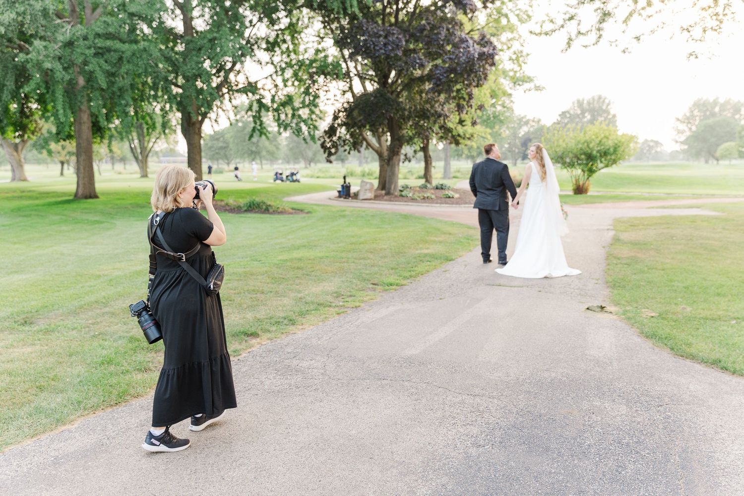 Cassie Lacina photographing a bride and groom walking together outdoors