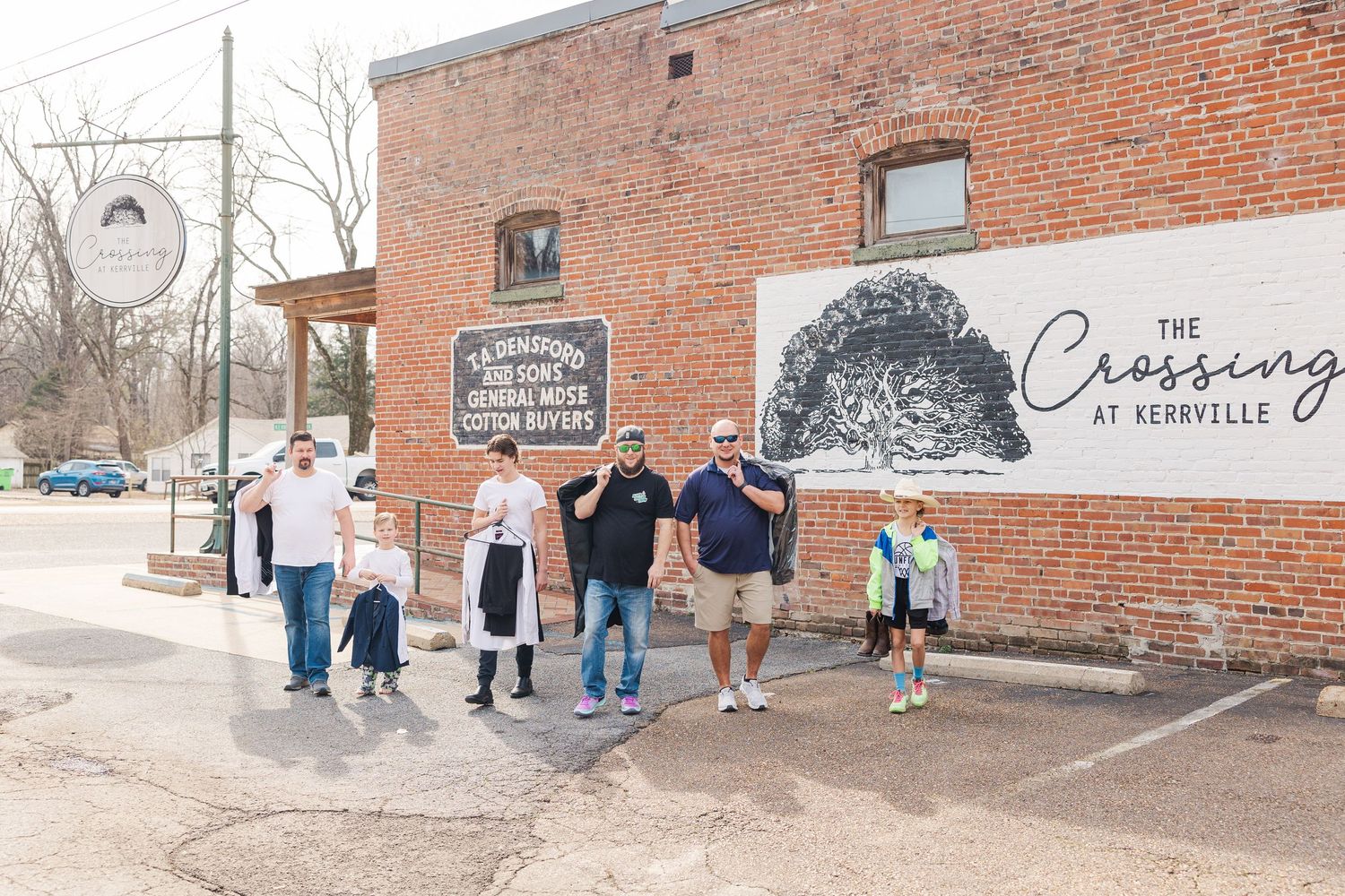 People gathered outside a historic brick building with The Crossing branding.