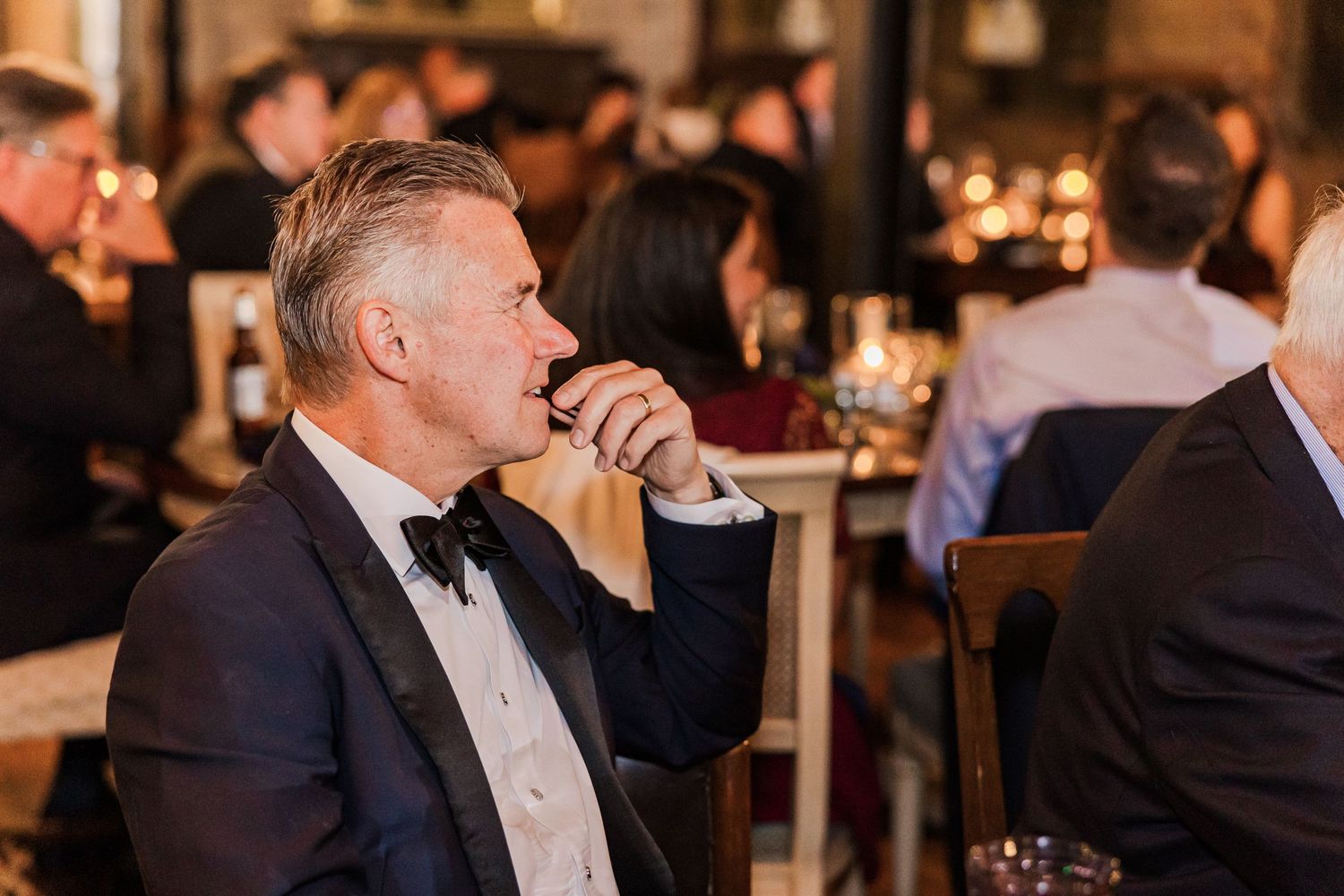 Wedding guest in formal attire enjoying drinks at reception.