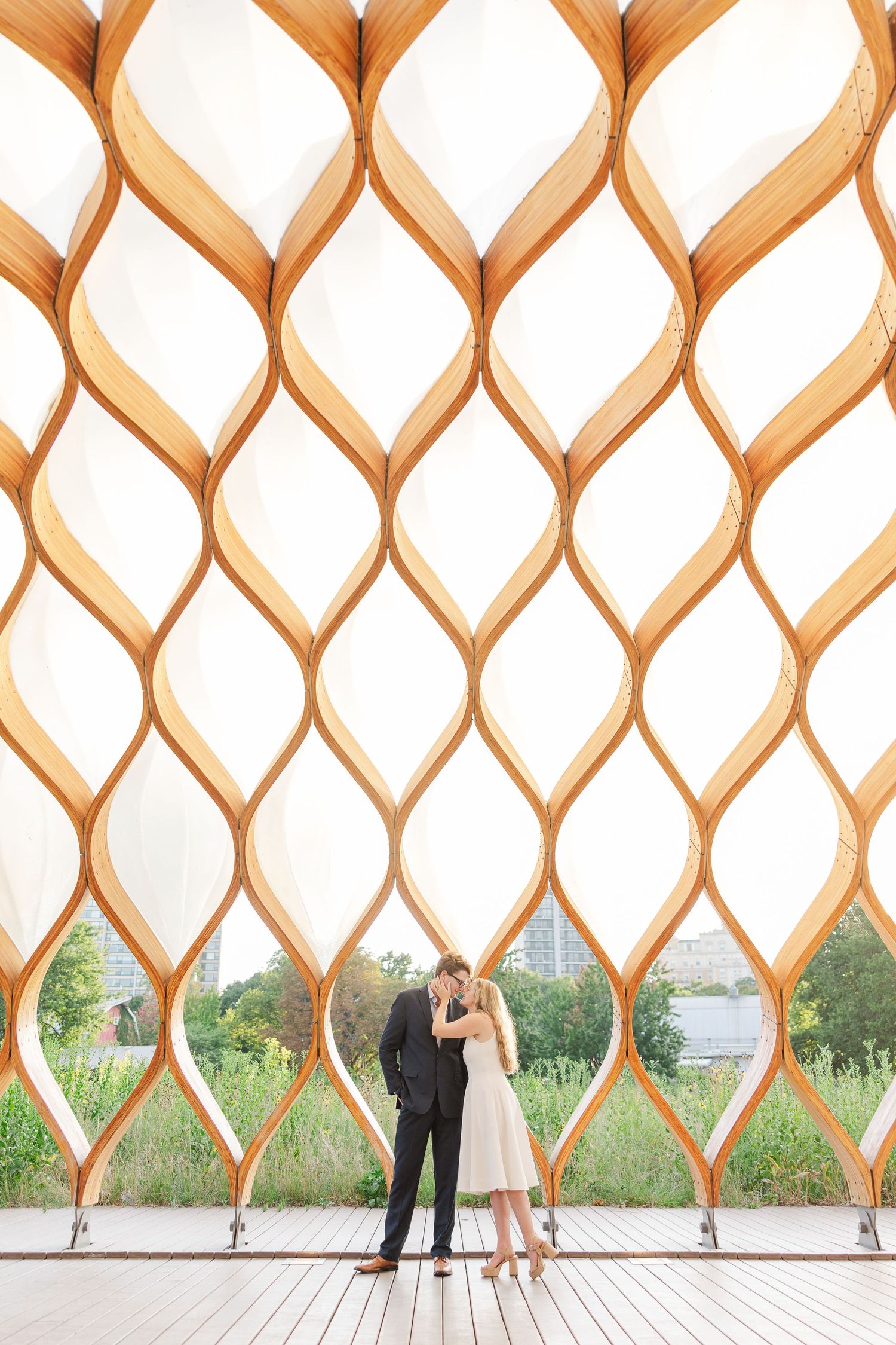 Elizabeth and Joe standing under the Honeycomb Pavilion in Lincoln Park, Chicago, smiling at each other