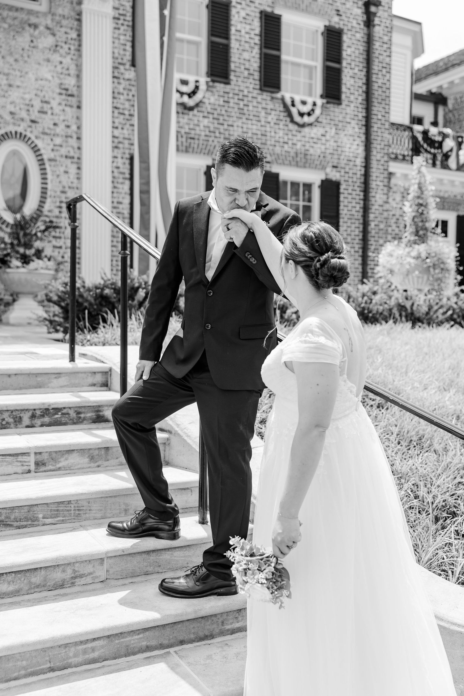 Black-and-white portrait of the bride and groom laughing together on the steps of McCormick House.