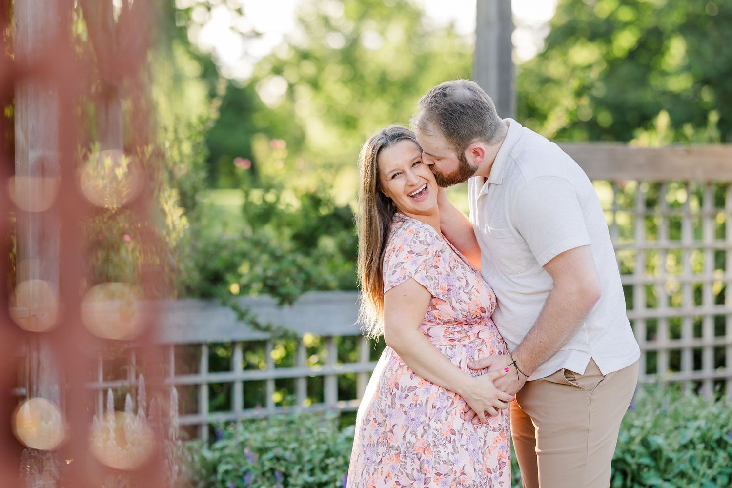 Smiling expecting couple cuddling together during a joyful Cantigny maternity session in Wheaton Illinois