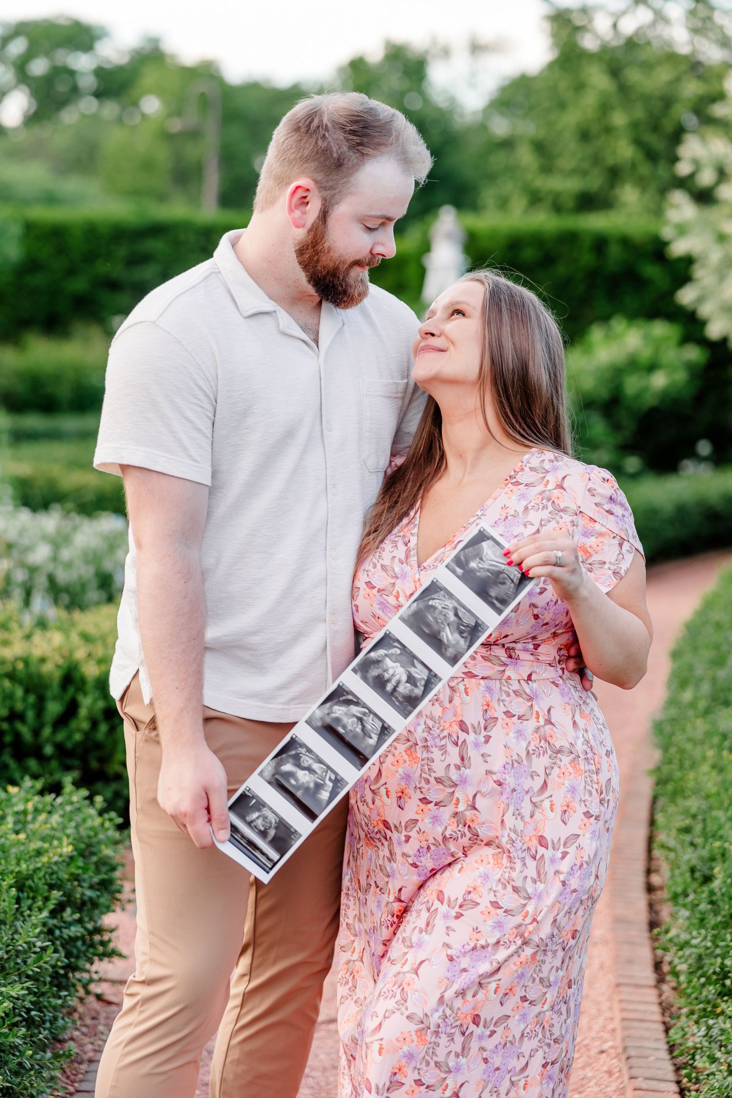 Expecting mother holding ultrasound photos during a Cantigny Park maternity session in Wheaton Illinois