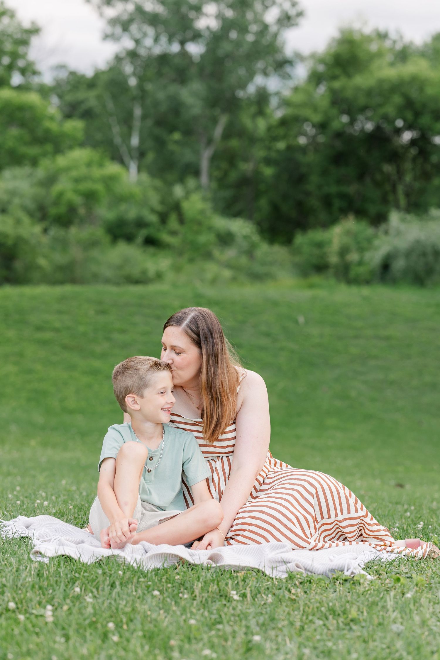 Mom cuddling her son on a blanket during a warm family portrait session in Crystal Lake.