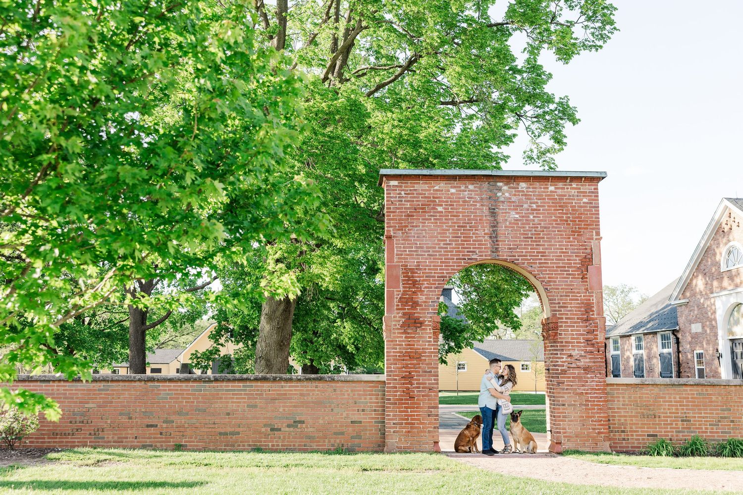 Wide engagement photo under the brick arch at St. James Farm Preserve