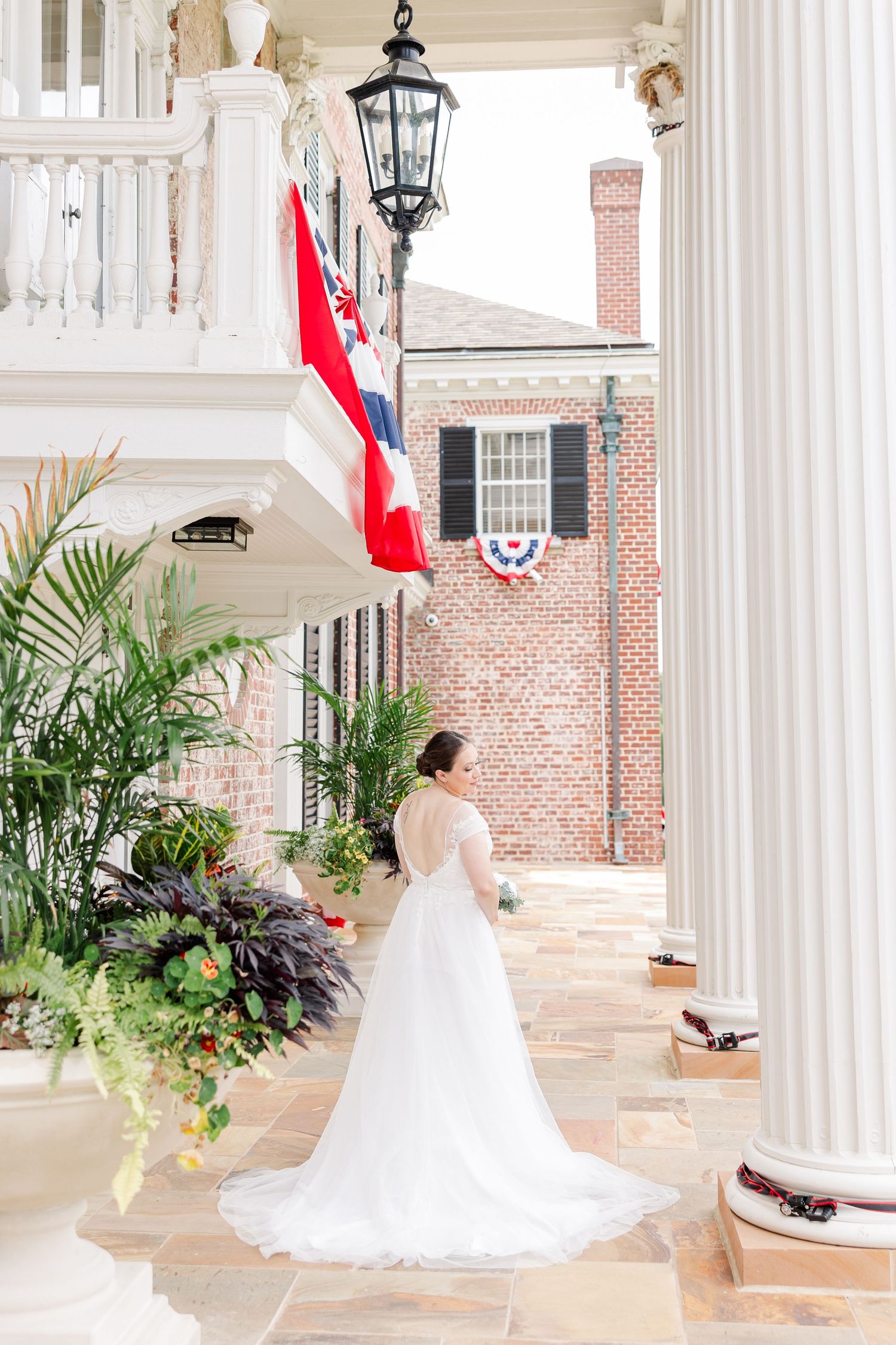 Bride showing the train of her wedding dress beneath the columns at McCormick House in Cantigny Park.