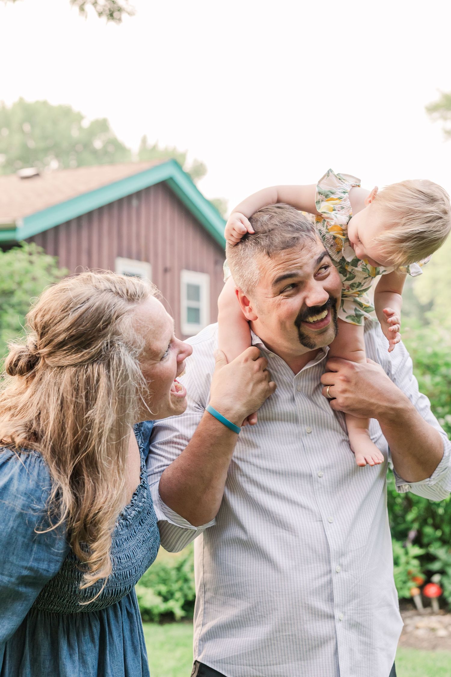 Candid family moment filled with laughter in a backyard garden setting.