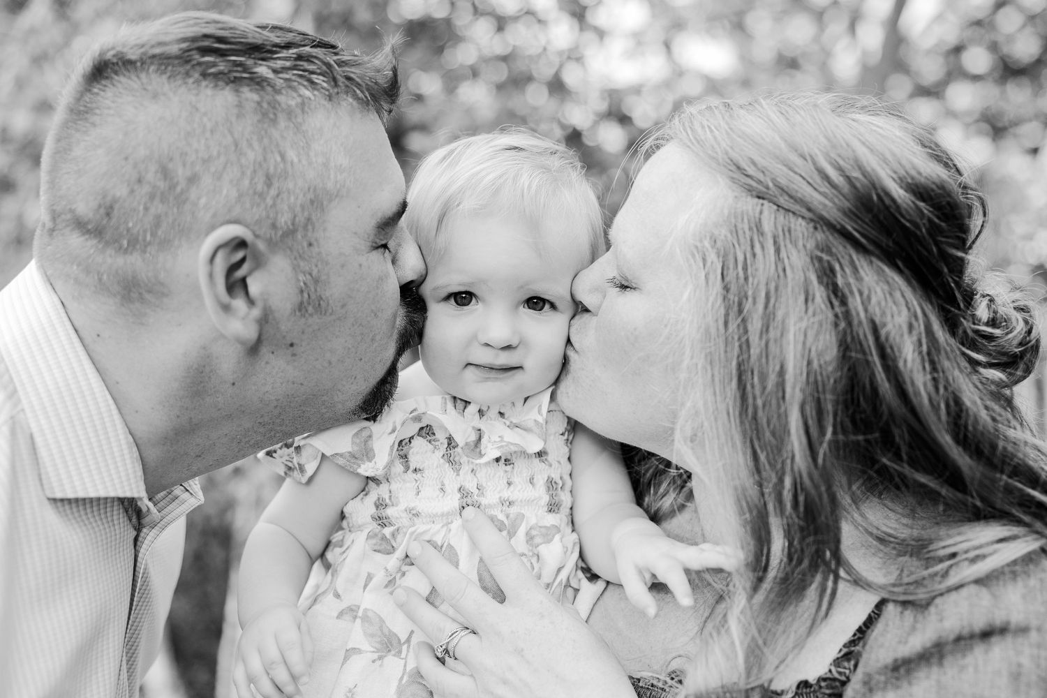 A tender family moment captured in black and white photography outdoors.