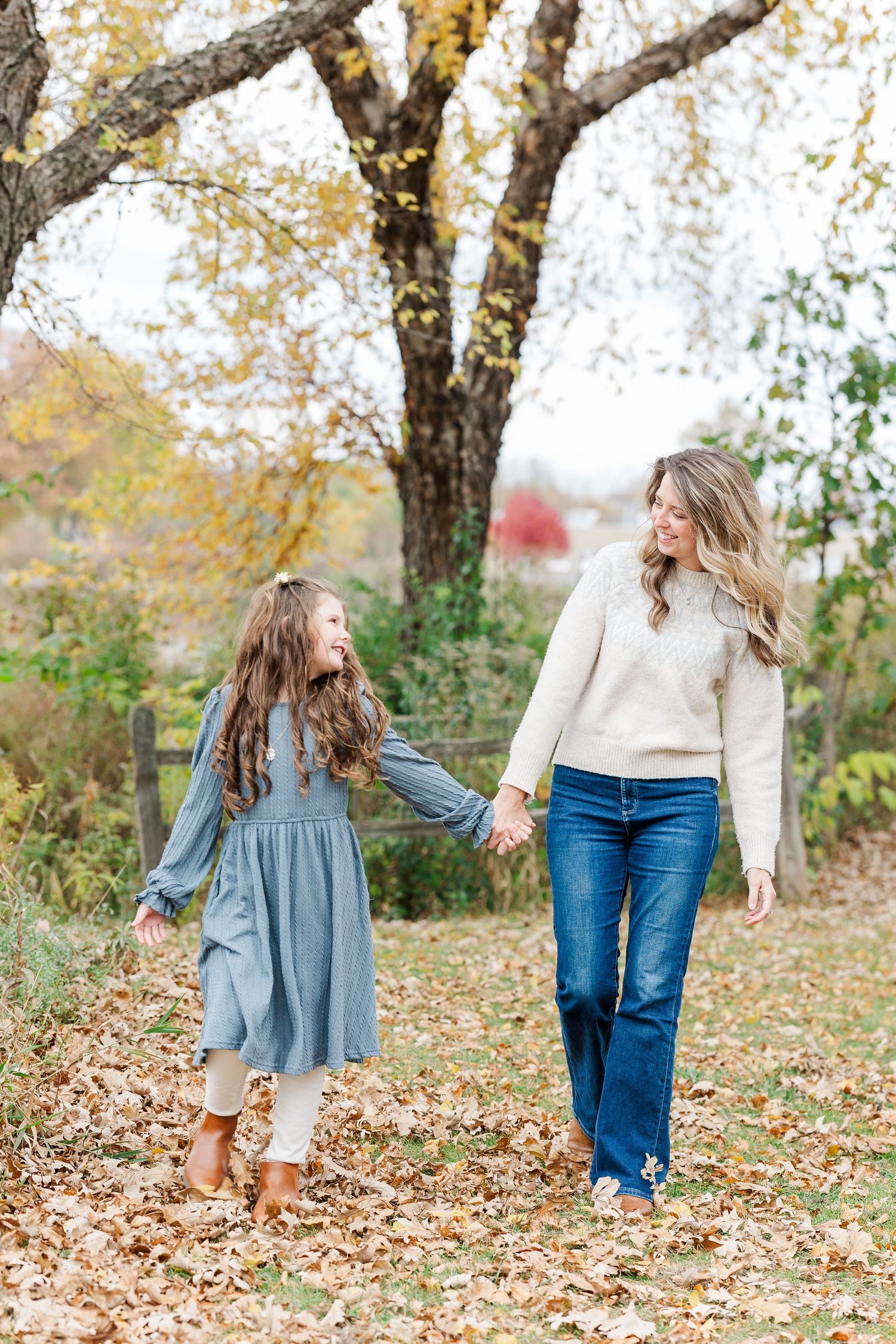 Mother and Daughter walking together in the autumn leaves at Jaycee Park in Cary, IL