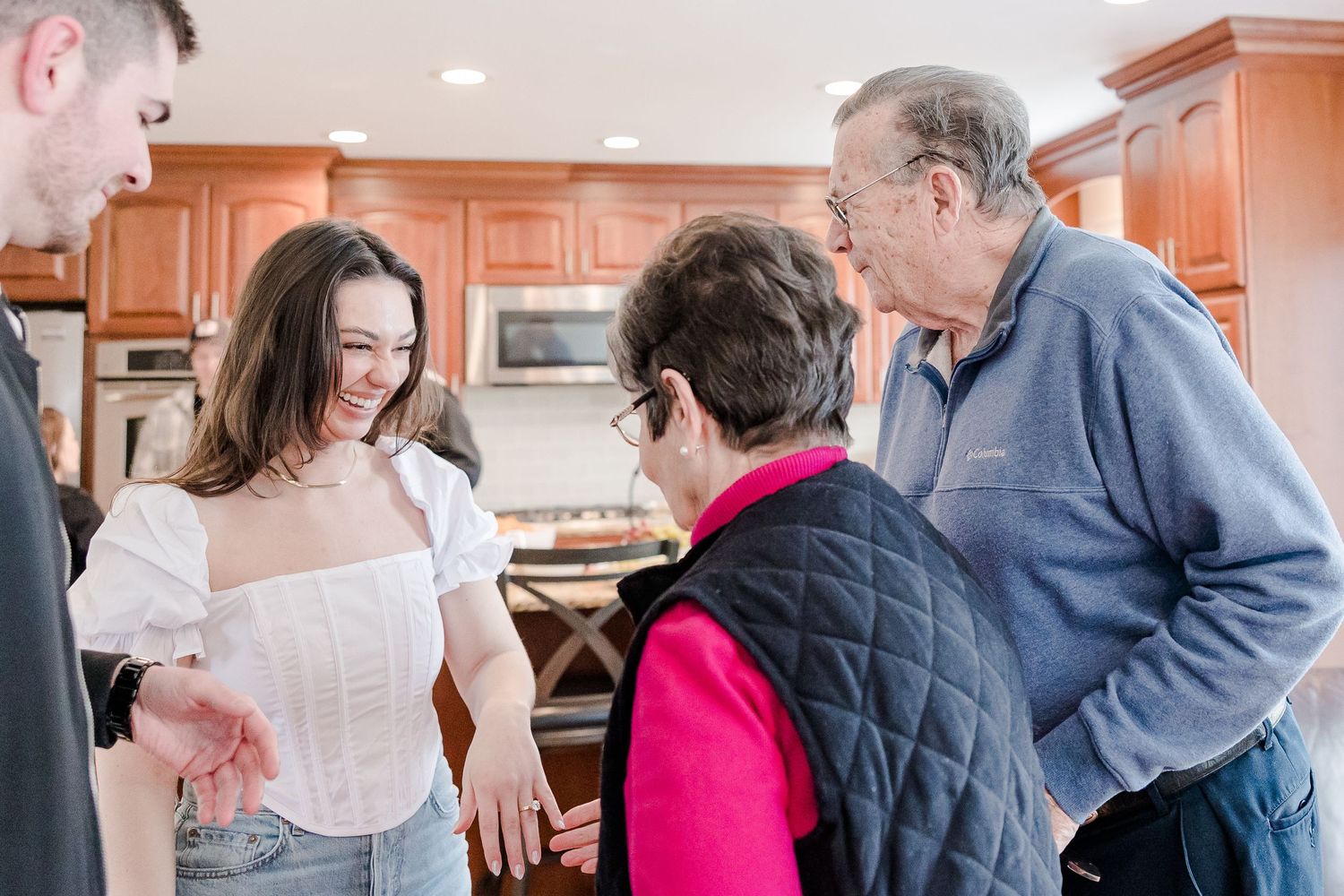 Group gathered in kitchen sharing happy moment together.