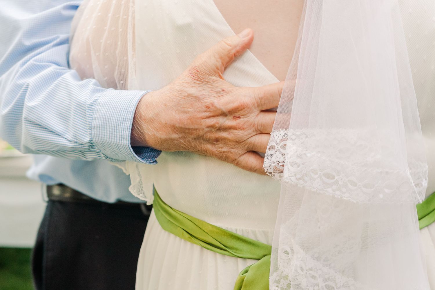 Close-up of hands tenderly embracing during a wedding ceremony.