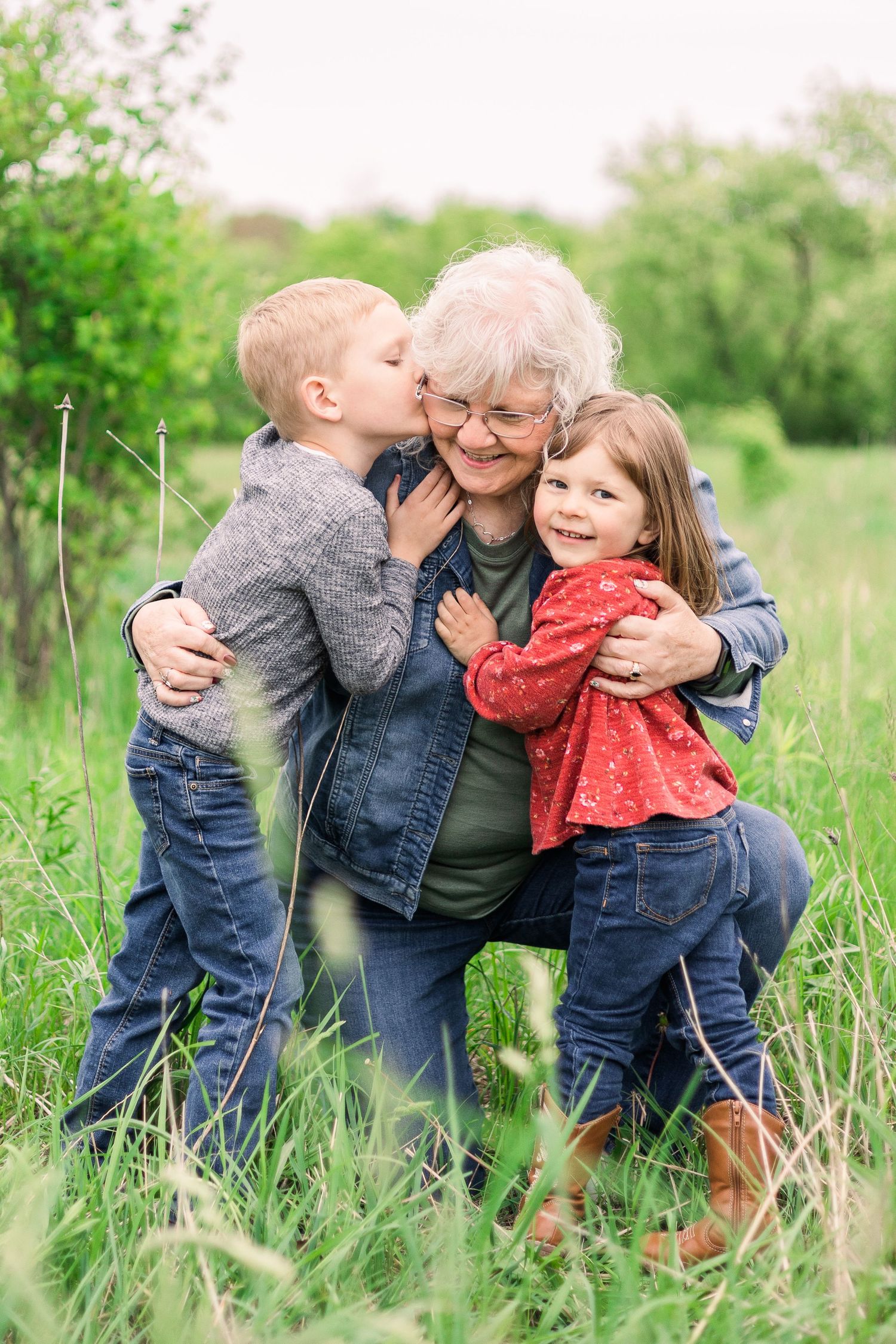 Sweet family moment captured in springtime meadow with embraces and smiles.