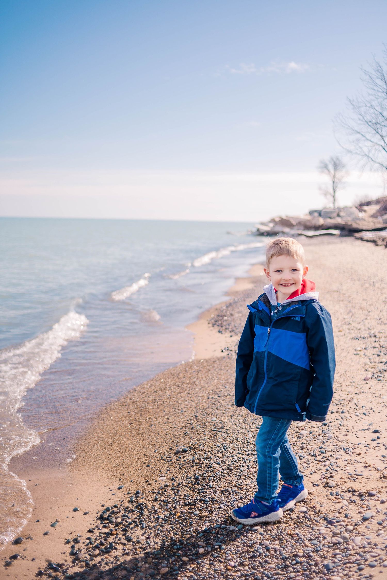 Sandy beach with gentle waves rolling onto shore on a clear winter day.