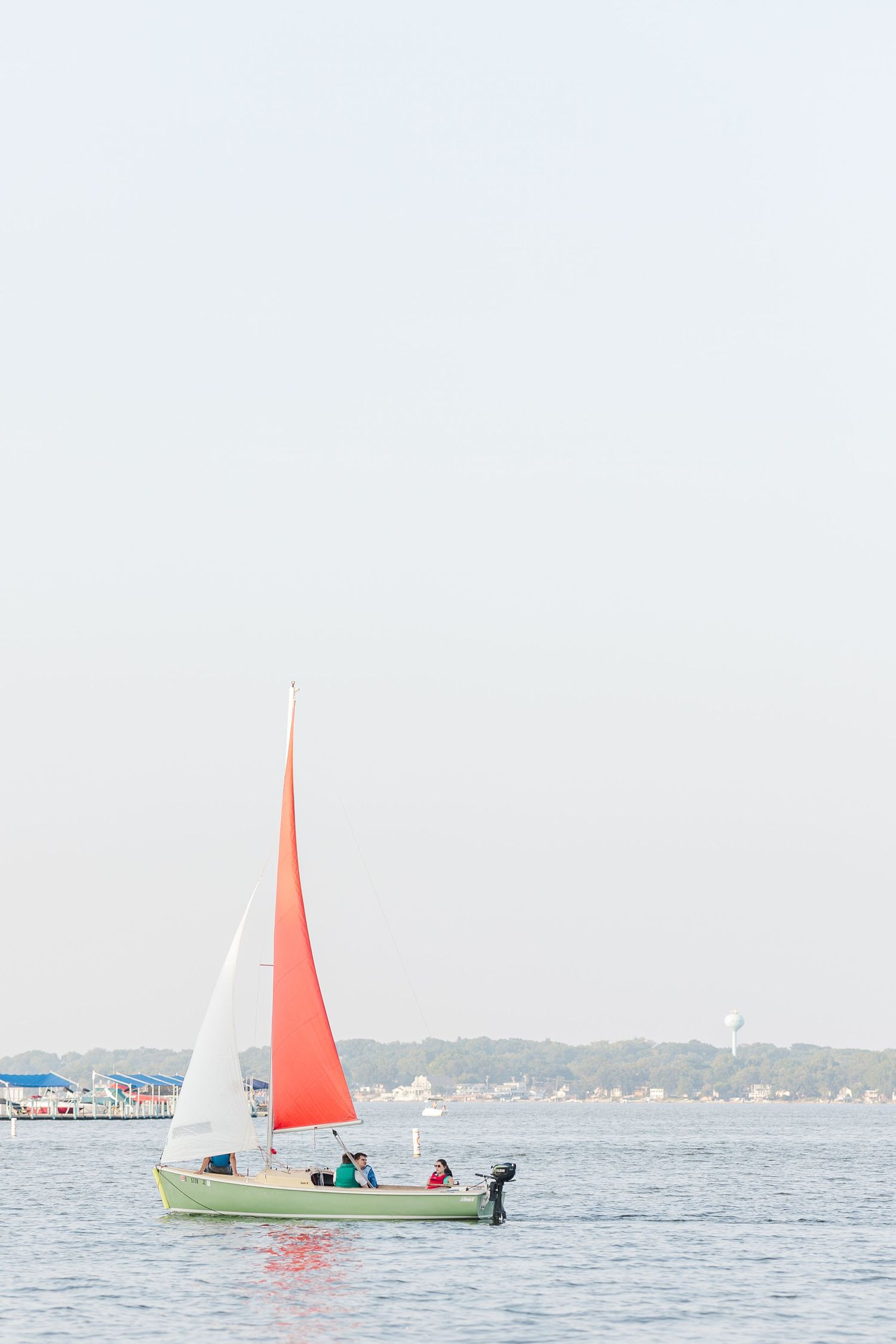 Red sailboat on Pistakee Lake during family photos in Johnsburg, Illinois