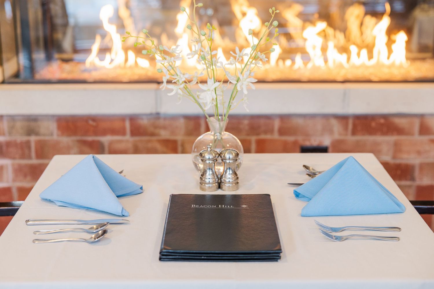 Beacon Hill senior living branding photo in Lombard, Illinois featuring dining table by fireplace