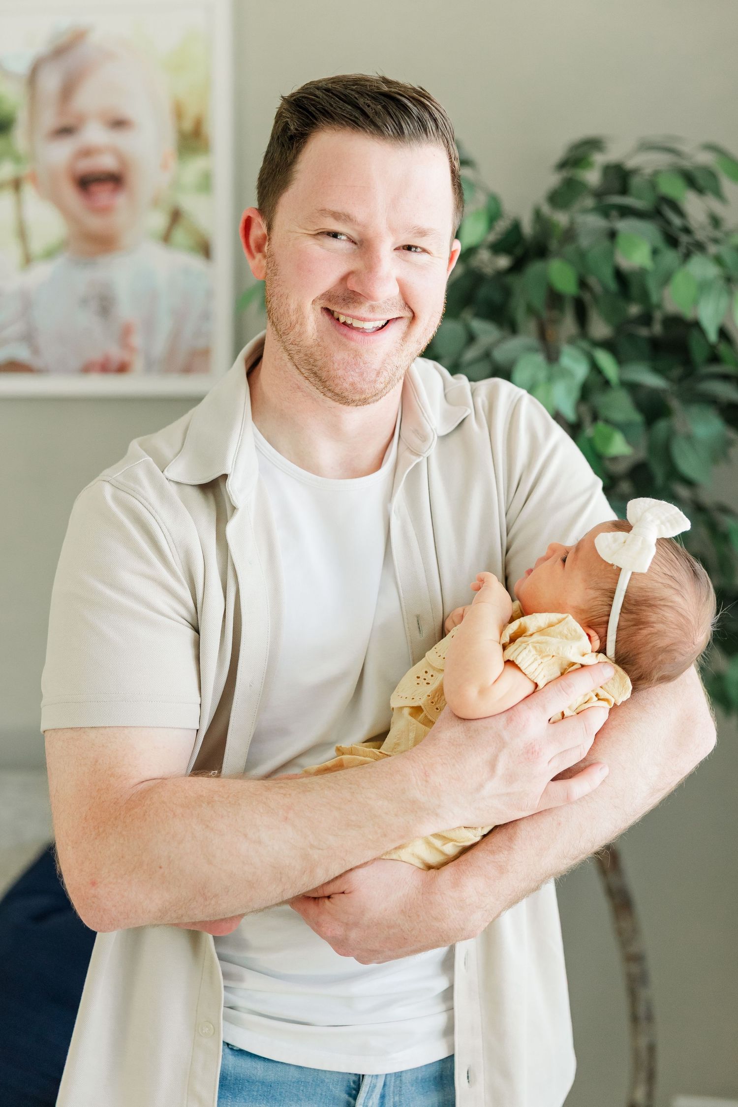 Dad smiling while holding newborn baby girl during a lifestyle newborn session in Huntley IL