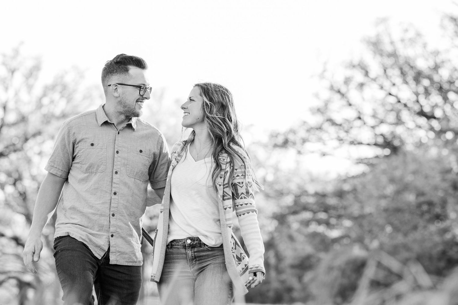 Black and white engagement portrait walking through St. James Farm Preserve