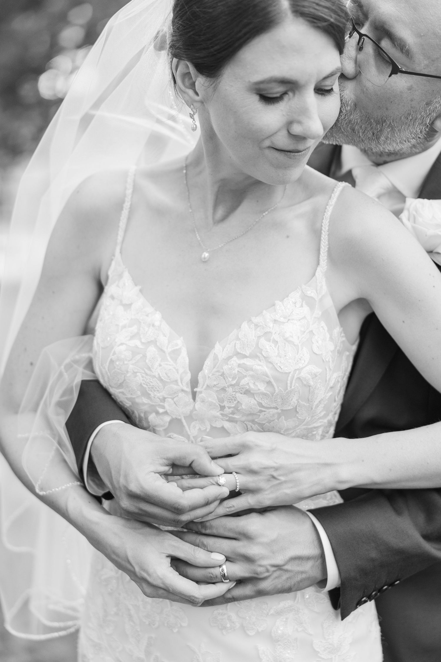 Intimate black and white wedding portrait showing tender moment between couple.
