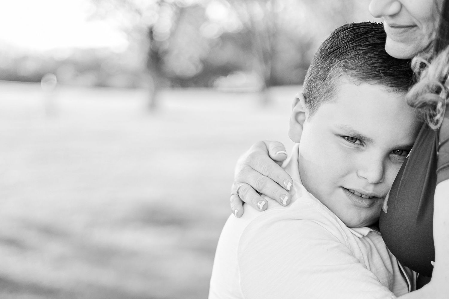 Black and white portrait showing emotional connection between two people in an outdoor setting.