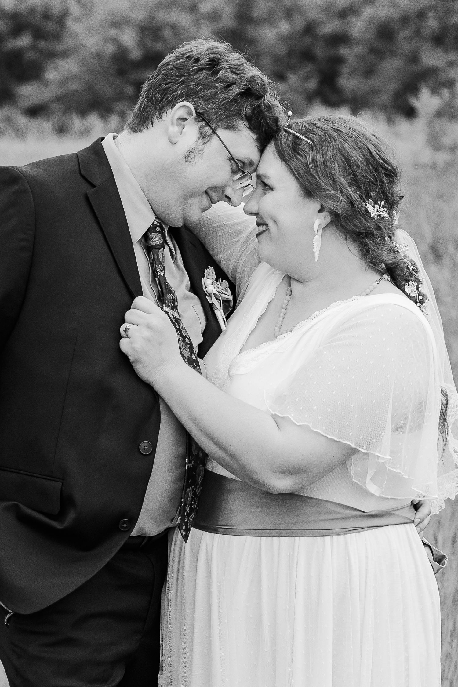 An intimate black and white wedding photo showing the couple sharing a close moment together.