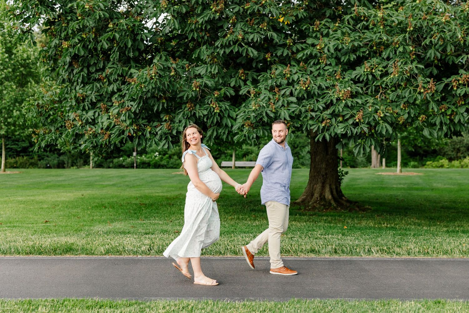 Expecting parents walking hand in hand during a relaxed maternity session at Cantigny Park