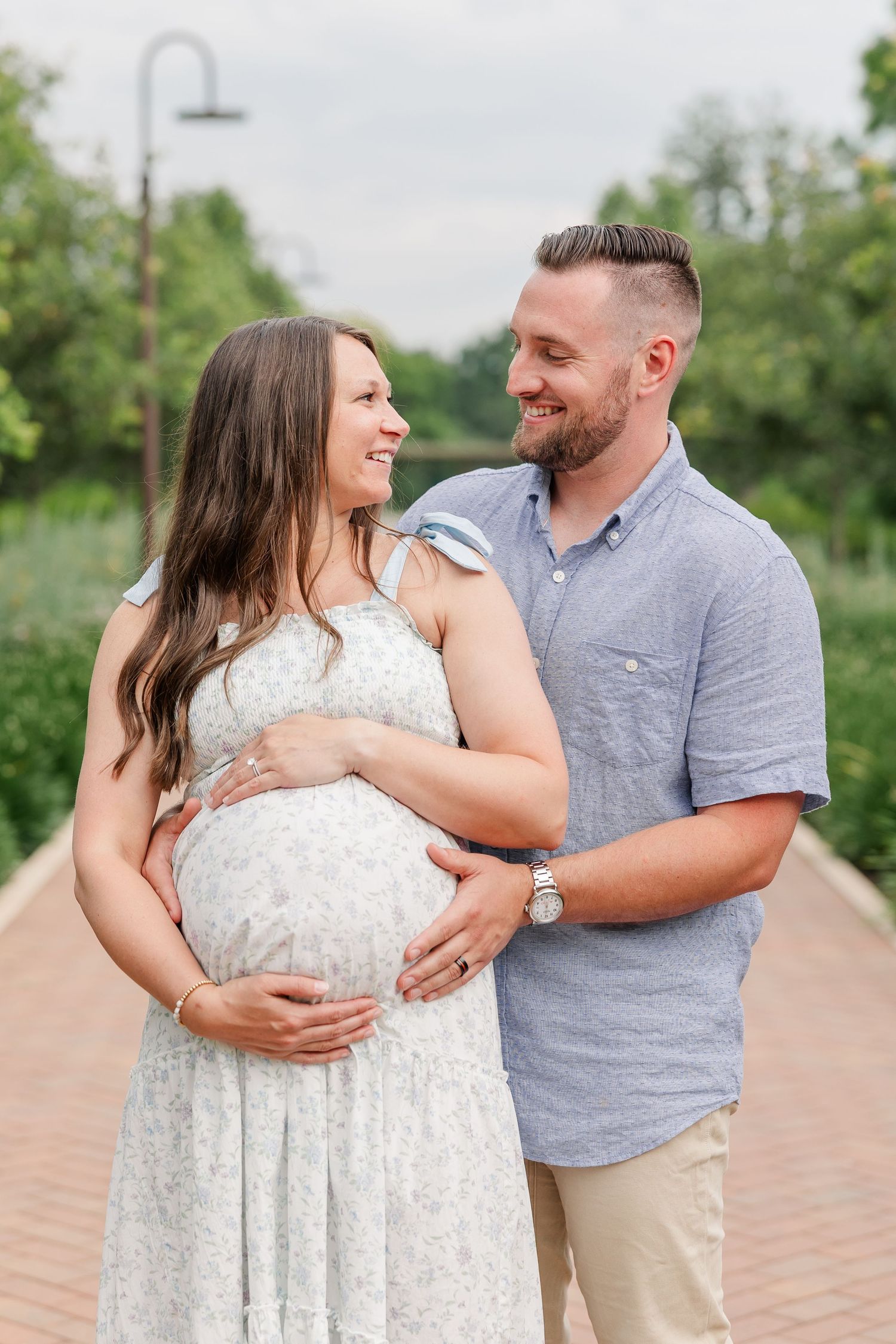 Expecting parents laughing together during a joyful maternity session at Cantigny Park