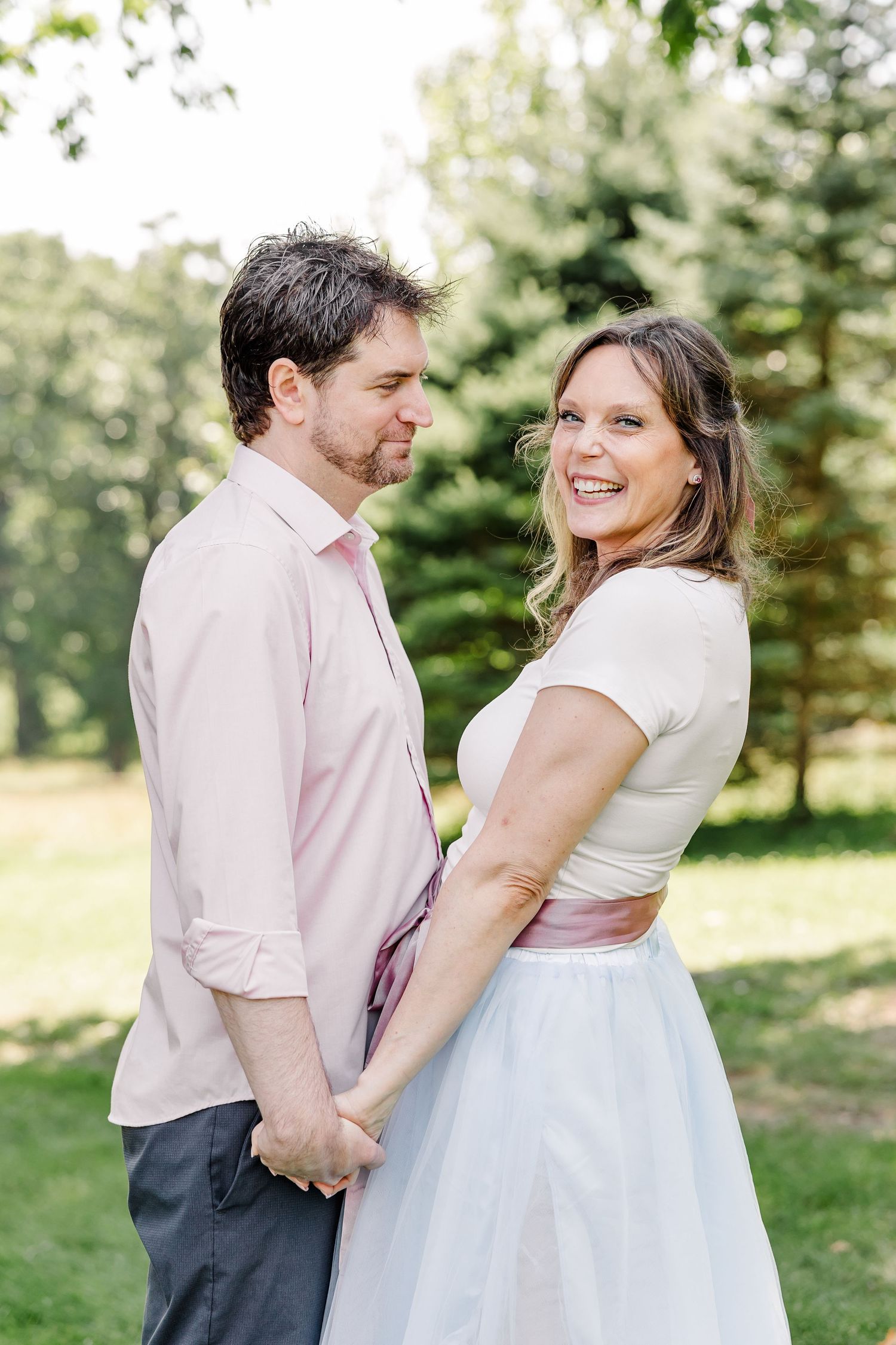 Couple holding hands during a bright outdoor family portrait session in Crystal Lake, IL.