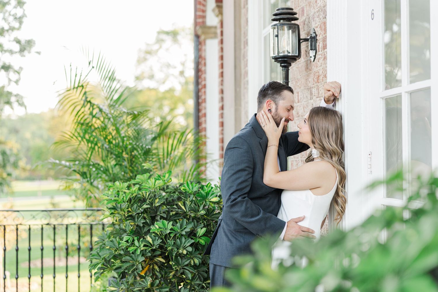 Couple kissing outside mansion during engagement photos at Cantigny Park in Wheaton, Illinois