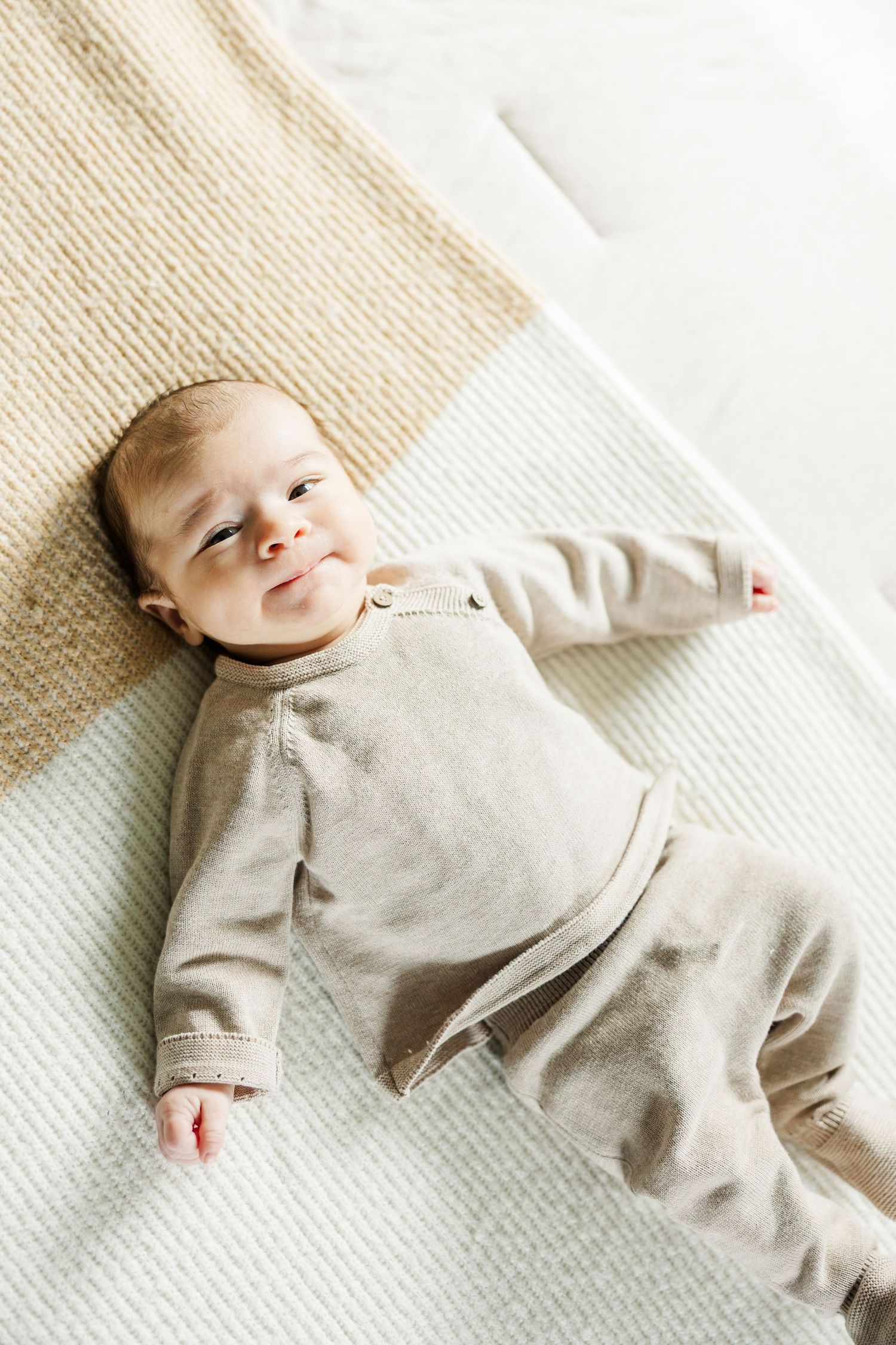 Newborn baby lying on a blanket looking up during an in-home lifestyle newborn photography session in Palatine IL