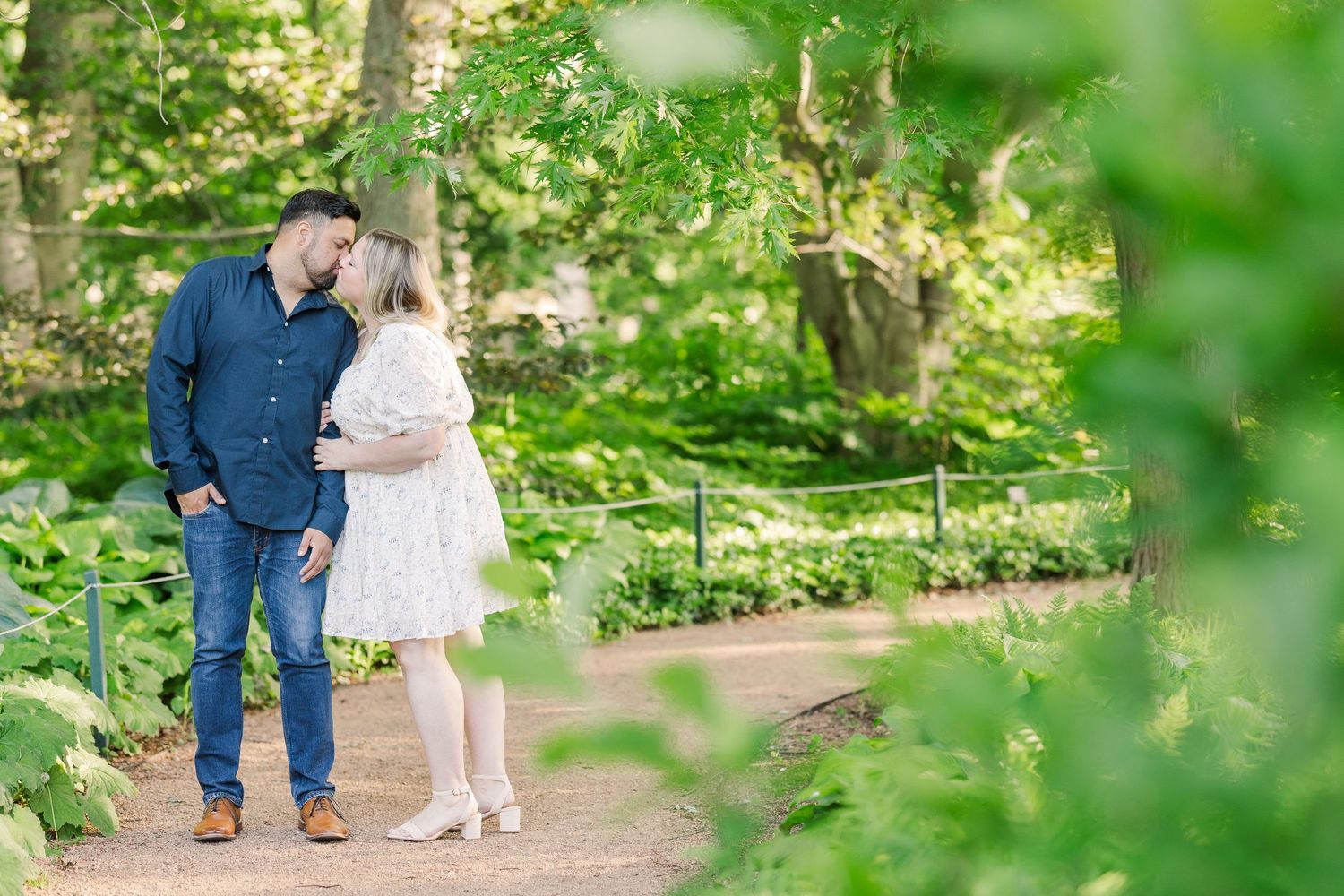 A tender moment shared between a couple on a peaceful garden trail.