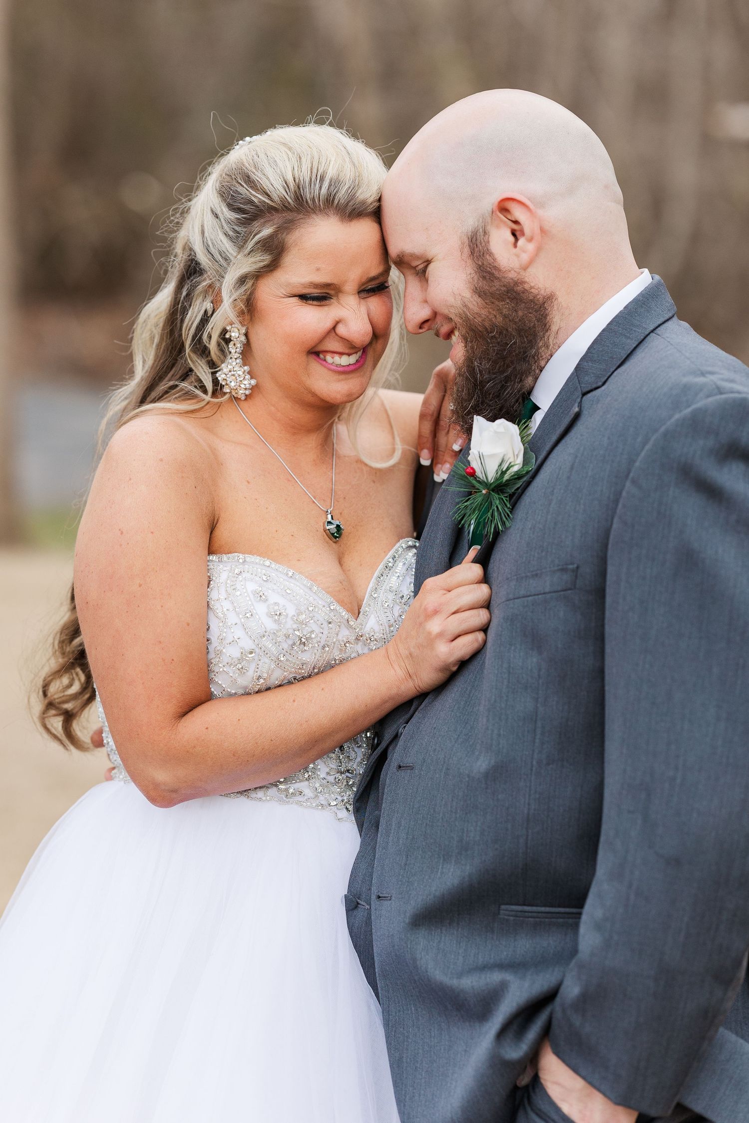Close-up wedding portrait capturing joyful laughter and intimate moment between newlyweds.