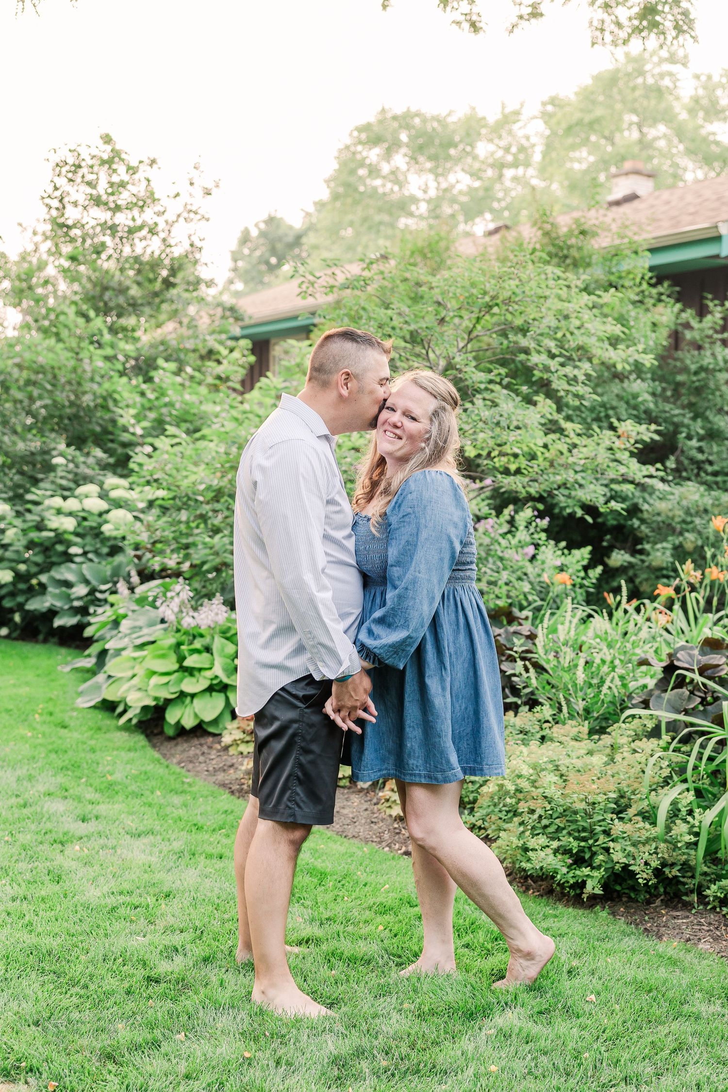Casual couple sharing an intimate moment in a lush garden setting.