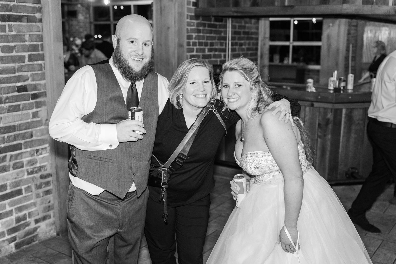 Black and white photo of wedding celebration at rustic venue.