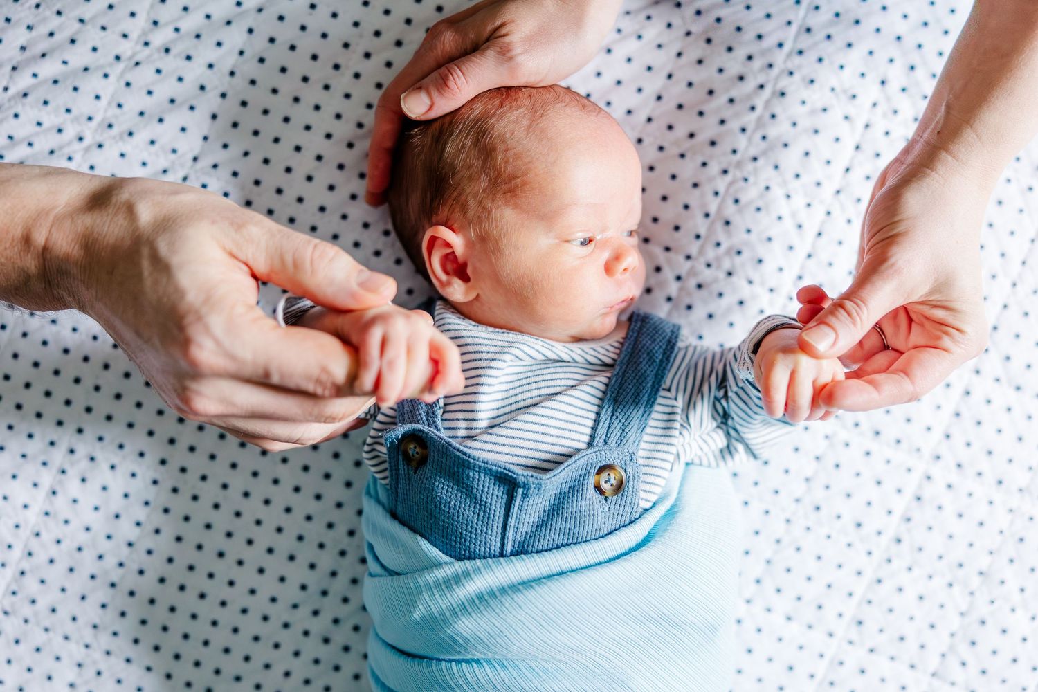 Newborn baby boy lying on bed during in-home lifestyle newborn session in Crystal Lake, Illinois