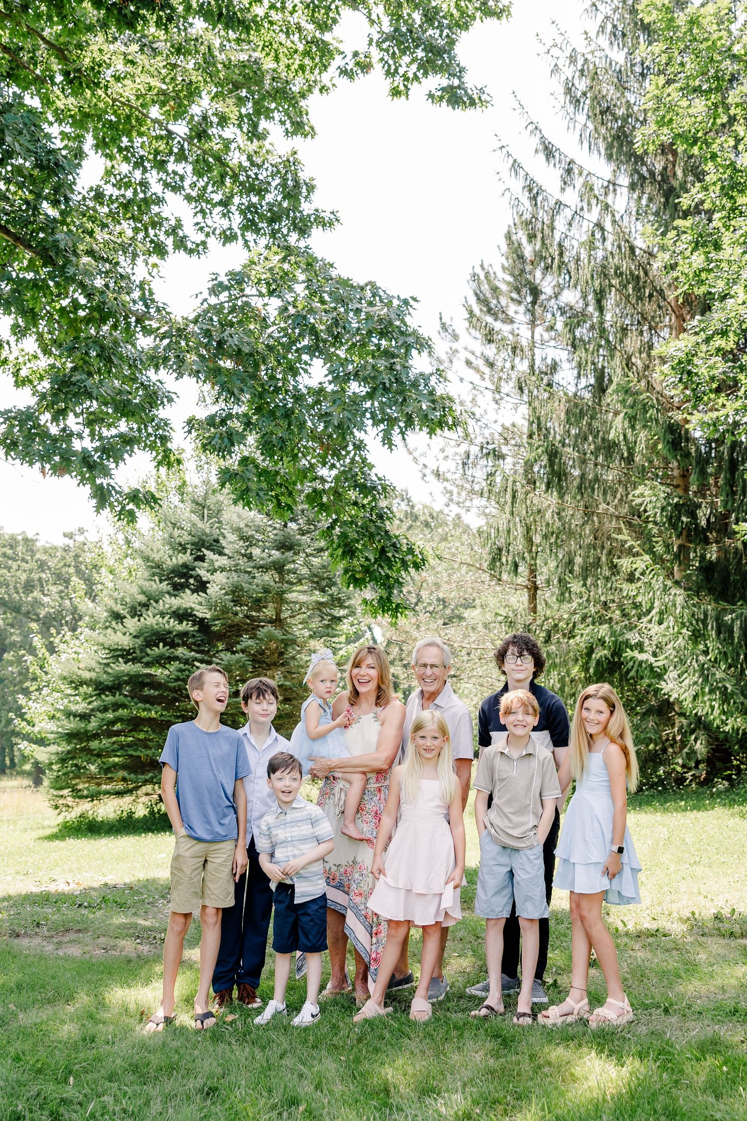 Multi-generation family portrait under the trees during a summer family reunion session in Crystal Lake, Illinois.