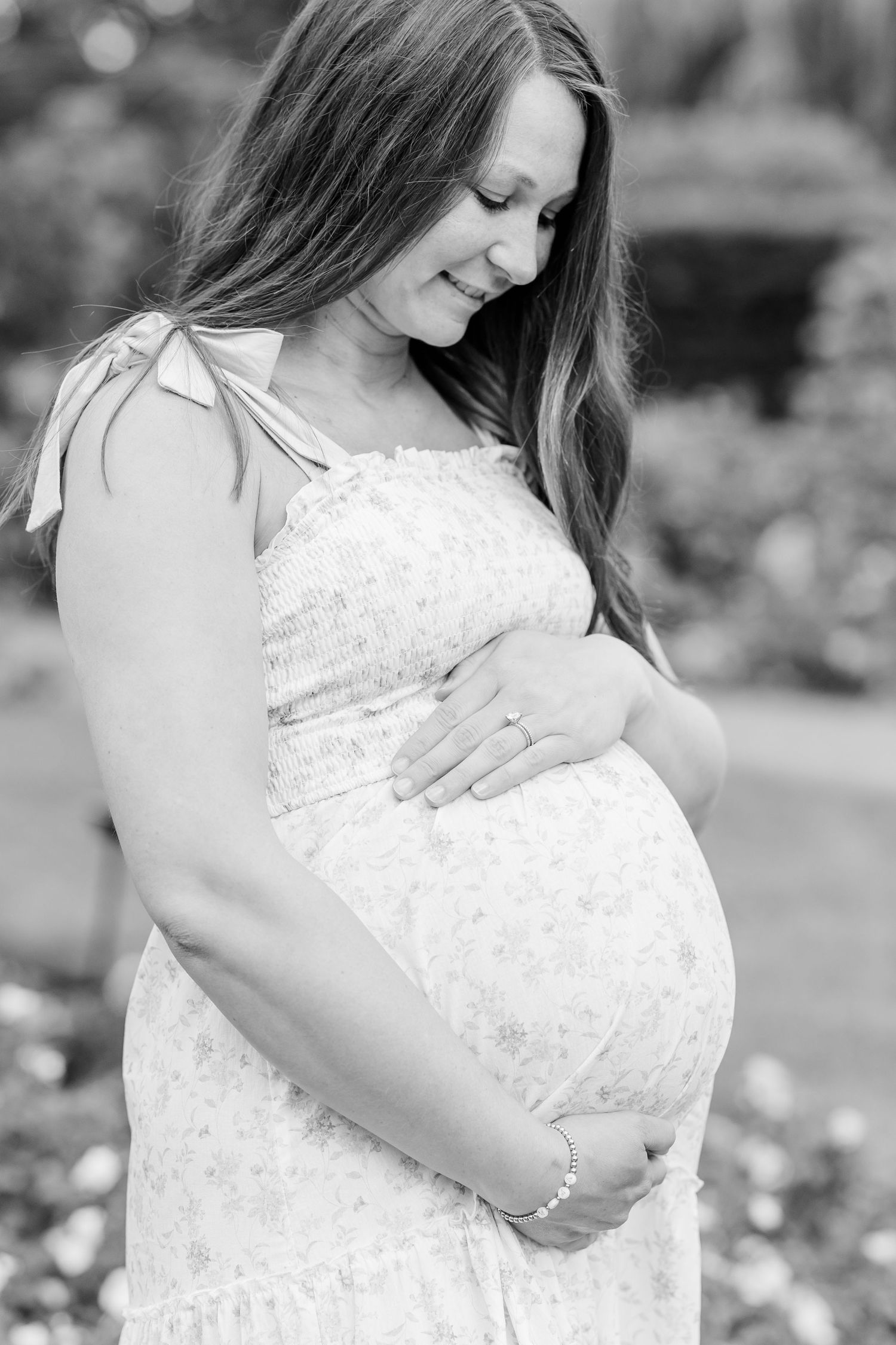Black and white maternity portrait of an expecting mother holding her baby bump