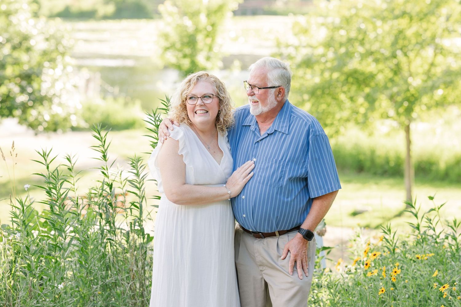 Grandparents hugging in soft summer light during a Crystal Lake extended family photo session at Veterans Acres Nature Center