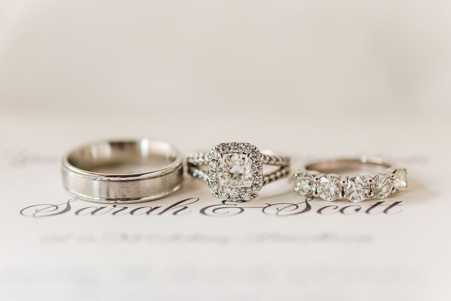 Wedding ring set featuring diamond engagement ring and matching bands on printed text.
