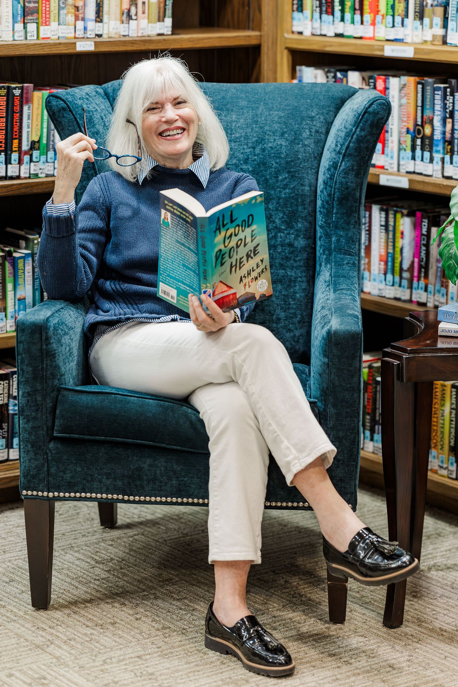 Beacon Hill senior living branding photo in Lombard, Illinois featuring resident smiling with book in library