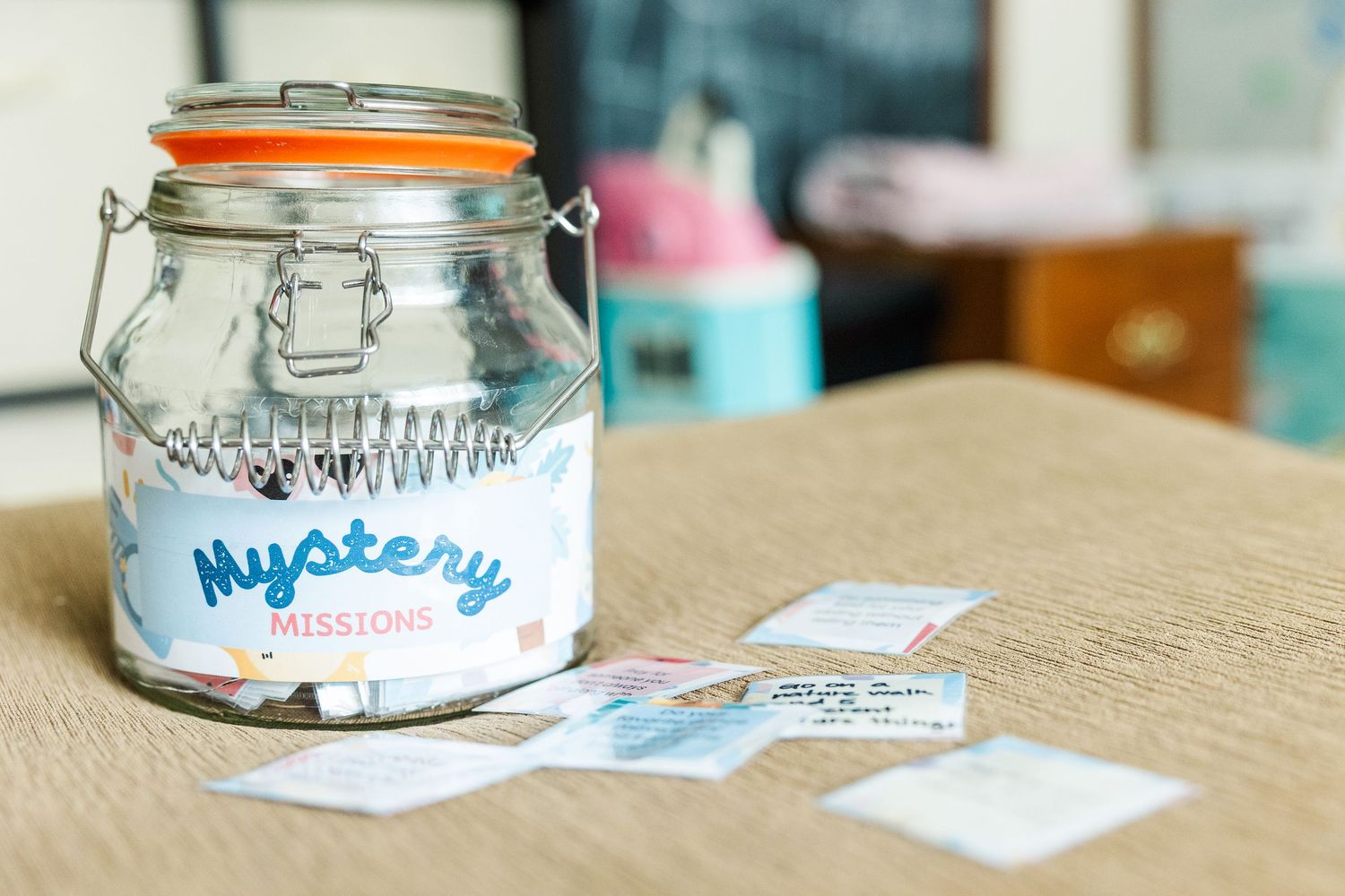 Glass jar filled with printable Mystery Mission cards for a kids summer routine and activity checklist