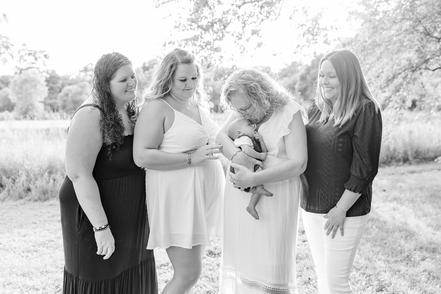 Black and white extended family photo with everyone admiring the baby during a Crystal Lake family portrait session