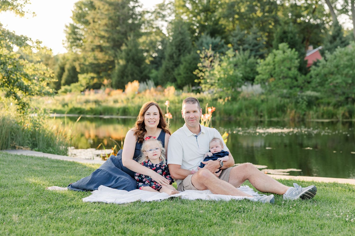 Hilary, Andrew, Caroline, and newborn Lincoln sitting together for outdoor family portraits at Cantigny Park.