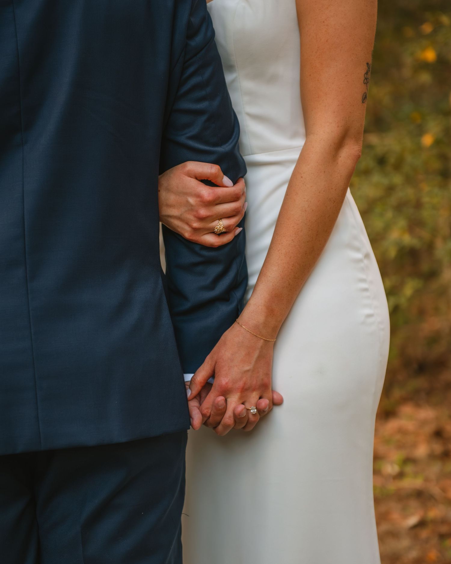Close-up of bride and groom holding hands, capturing an intimate and emotional wedding detail moment outdoors. In Charelston SC