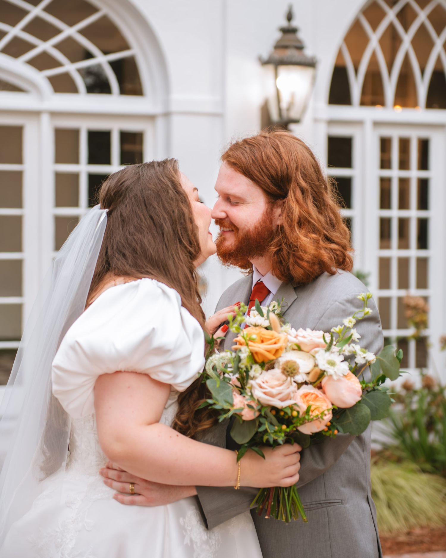 Bride and groom embracing and smiling during a romantic outdoor wedding portrait.
 At Lowndes Grove Charleston SC