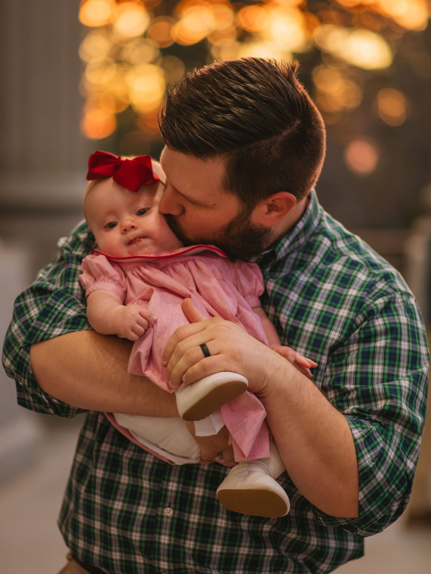 Father holding baby girl in a soft, emotional moment during a family session at the South Carolina State House