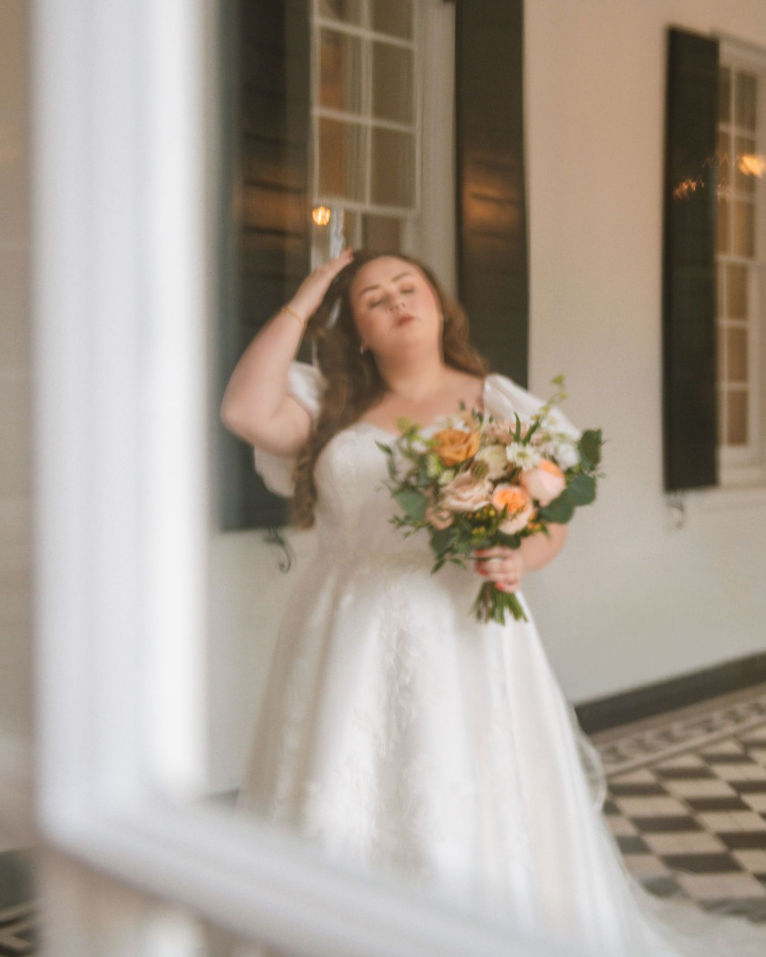 Bride holding bouquet and posing on porch during a soft bridal portrait session At Lowndes Grove Charleston SC